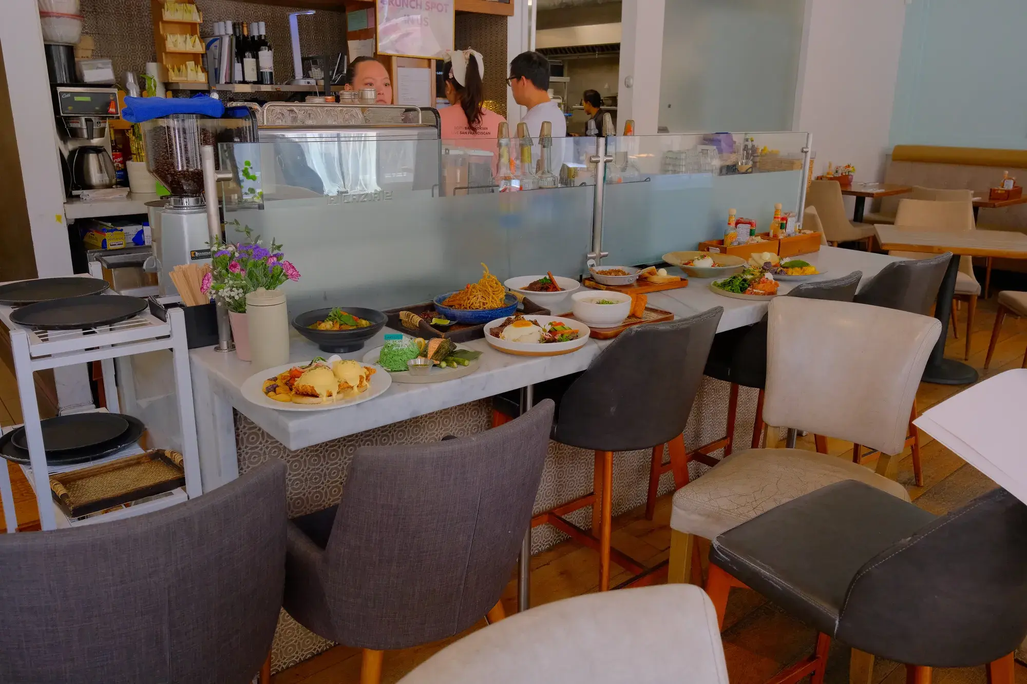 Set tables and chairs in the Lapisara dining room, with the counter behind