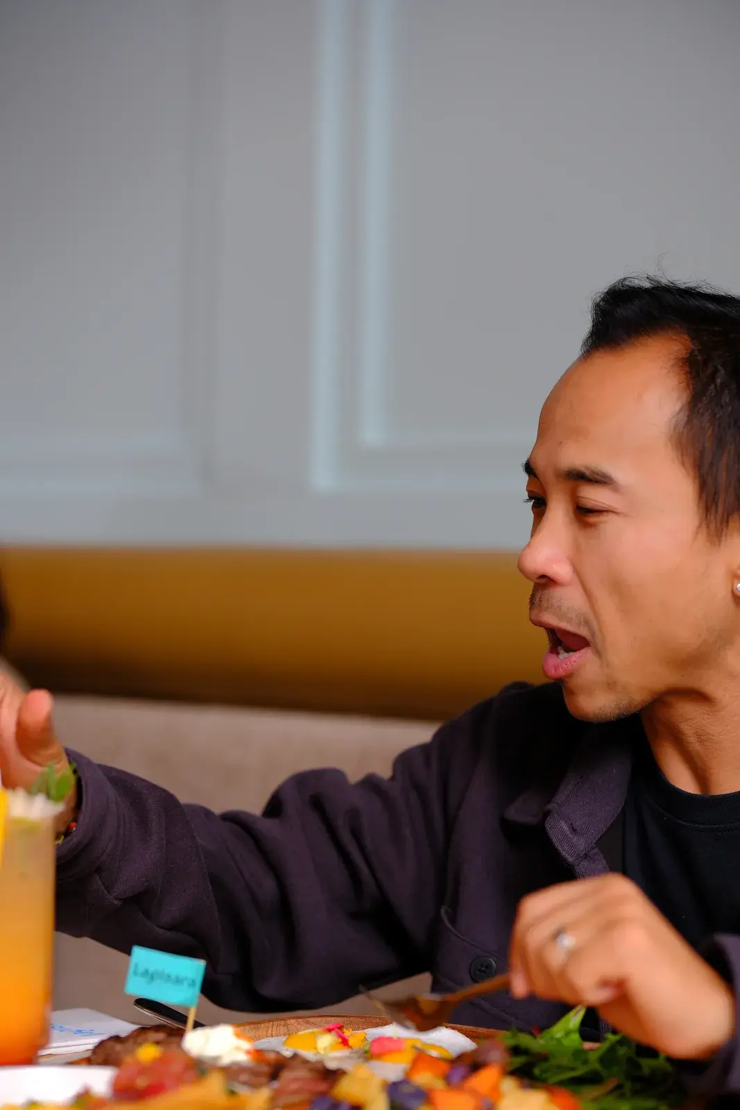 A guest talking across a table set with brunch plates