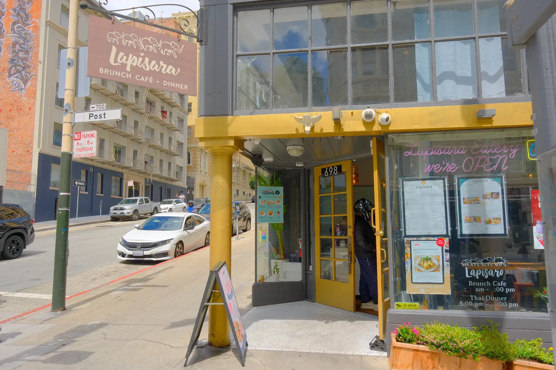 The Lapisara storefront on Post Street, yellow doorframe and sign, seen from the pavement
