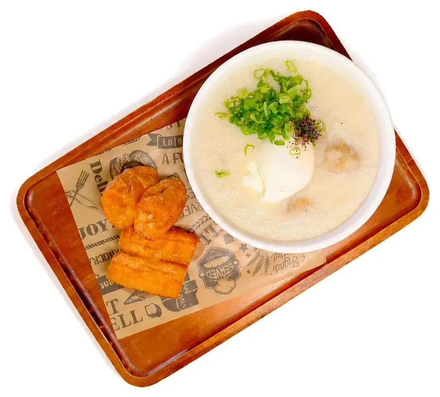 A bowl of chowder with toast on a copper tray
